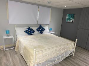 a bedroom with a white bed with blue pillows at Bancroft VIBES l Sleep 7 l BBQ I FIRE PIT in Bancroft