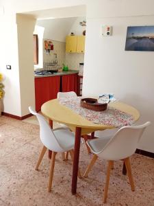 潘泰莱里亚Belvedere的厨房配有木桌和白色椅子