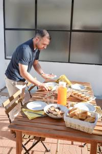 a man standing at a table with food on it at Casa da Laranja by Quantique in Peso da Régua