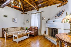 a living room with a couch and a fireplace at Pefkos Cottage in Panormos Skopelos