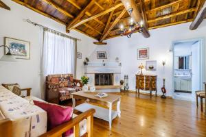 a living room with a fireplace and wooden floors at Pefkos Cottage in Panormos Skopelos
