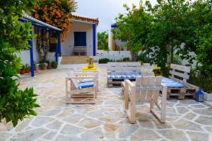 eine Terrasse mit 2 Stühlen, einem Tisch und 2 Stühlen in der Unterkunft Marini Traditional Cottages in Khlóï