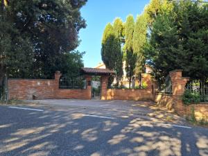 a brick house with a gate and a driveway at Biancolilla House in Rosignano Solvay