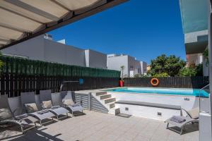 a swimming pool with lounge chairs next to a building at Vila Cantinho Algarvio Vista Rio in Ferragudo