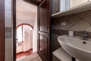 a bathroom with a sink and a mirror at Residenza il Vicolo del Corso in Massa Marittima