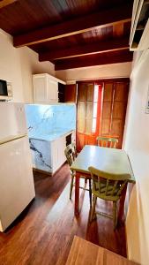 a kitchen with a table and chairs and a refrigerator at Apart Hotel Géminis in Termas del Daymán