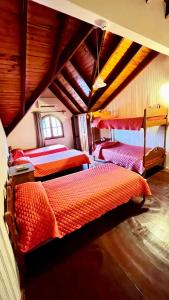 a bedroom with three beds in a attic at Apart Hotel Géminis in Termas del Daymán