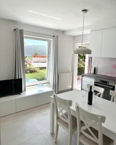 una cucina bianca con tavolo e sedie bianchi di ArtApArt T a Rabac