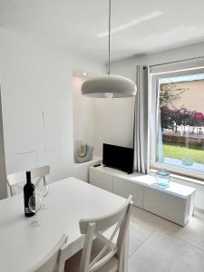 una sala da pranzo bianca con tavolo bianco e finestra di ArtApArt T a Rabac