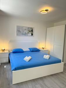 una camera da letto con letto con lenzuola blu e cuscini blu di ArtApArt T a Rabac