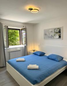 una camera da letto con un grande letto blu con due cuscini di ArtApArt T a Rabac Altre 7 foto