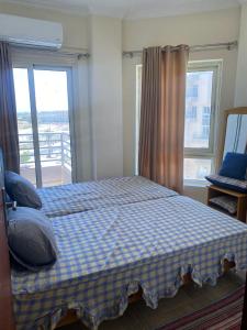ein Schlafzimmer mit einem Bett mit einer karierten Decke in der Unterkunft Princess resort 307 in Hurghada