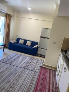 ein Wohnzimmer mit einer blauen Couch in einer Küche in der Unterkunft Princess resort 307 in Hurghada