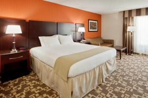 
a hotel room with a large bed and a large mirror at Holiday Inn Express Wilkes Barre East, an IHG Hotel in Wilkes-Barre

