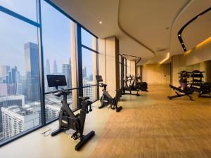 une salle de sport avec des tapis roulants et des appareils d'exercice dans un bâtiment dans l'établissement Axon Residence KLCC - JD HOME, à Kuala Lumpur
