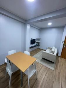 a dining room with a table and a couch at Ravenala - Apartment Paracas in Paracas