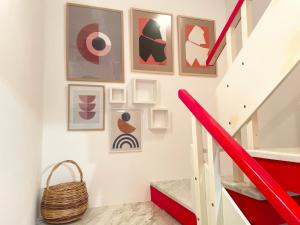 eine Treppe mit rotem Geländer und Bildern an der Wand in der Unterkunft Lalëz AZURE Villa - 3 Bedrooms in Lalzit Bay