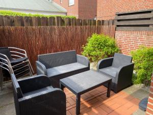 three chairs and a table and two chairs on a patio at Sandbank in Langeoog