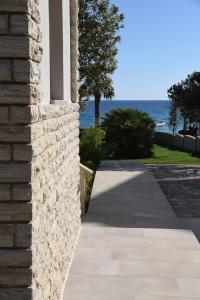 诺瓦利娅Suites Villa Ropuš的海边有一条步道的石头建筑