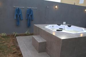 a bath tub in a bathroom with blue jackets on a wall at CASA COM SPA de HIDRO COM AQUECEDOR a 700 MTS DO CENTRO in Chapada dos Guimarães +19 photos