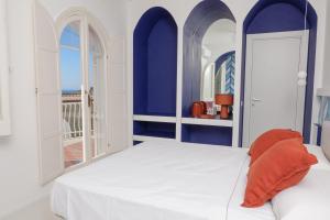 una camera da letto con pareti blu e un letto con un cuscino arancione di La Maison De La Ville a Massa Lubrense
