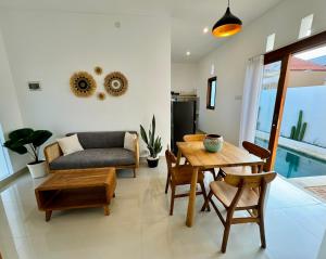 een woonkamer met een tafel en een bank bij Lily House Cozy 2 bedrooms Villa with Pool in Bukit in Nusa Dua