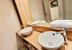 łazienka z białą umywalką i lustrem w obiekcie Résidence Neige Et Soleil - Studio 4 personnes à Tignes au pied des pistes et proche des commerces dans le quartier du Rosset. Studio très bien agencé avec MAE-1806 w mieście Tignes