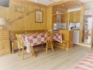 ティーニュにあるRésidence Le Palafour - Studio 5 personnes à Tignes au pied des pistes, des commerces, de l'ESF et de l'office du tourisme dans le quartier du lac. App MAE-2052の部屋にテーブルと椅子のあるキッチン
