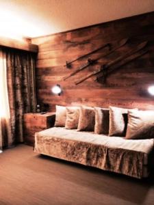 a bedroom with a bed with a wooden wall at Résidence La Frasse - Joli studio pour 4 personnes à Meribel proche des pistes dans le quartier du Morel MAE-2097 in Les Allues