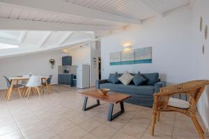 a living room with a blue couch and a table at Oceanis Rooms Apartments in Barbati