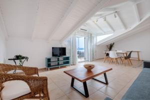 a living room with a couch and a table at Oceanis Rooms Apartments in Barbati