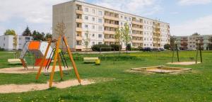 an empty playground in a park in front of a building at Kitse 26 Apartment , Self Check-in, Free Parking in Pärnu