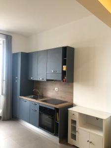 a kitchen with blue cabinets and a stove top oven at La Maison sul Porto in Anzio