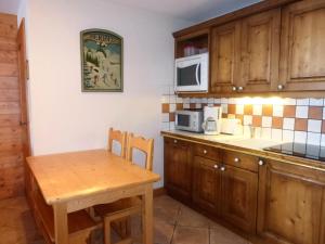 a kitchen with a wooden table and a microwave at Résidence Bergerie Des 3 Vallees D - Joli appartement 3 pièces 4 personnes situé sur Les Allues dans un quartier calme MAE-2122 in Les Allues +6 photos