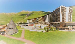 vista su una città con edifici e un prato di Résidence Le Palafour - Studio 2 personnes à Tignes au pied des pistes, des commerces, de l'ESF et de l'office du tourisme dans le quartier du lac. Appa MAE-2160 a Tignes