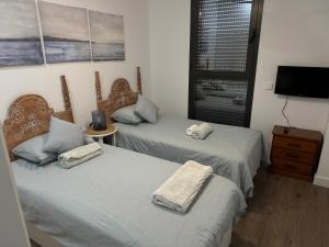 two twin beds in a room with a tv at Golden view costa del sol in Torre del Mar +14 photos