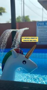 a toy shark in a swimming pool with a sign at Dj Impiana Homestay - Private Kids Pool in Kampung Raja
