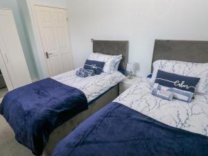 two beds sitting next to each other in a room at Bluebell Cottage in Cardiff