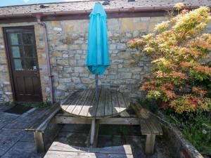 a blue umbrella sitting on top of a wooden table at Bluebell Cottage in Cardiff +6 photos