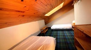ein Dachzimmer mit zwei Betten und Holzdecken in der Unterkunft Résidence BruyÈres - Les Hauts De Planchamp - 3 Pièces pour 6 Personnes MAE-3322 in Champagny-en-Vanoise