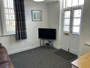 a living room with a flat screen tv in the corner at Mowbray Grange in Bedale