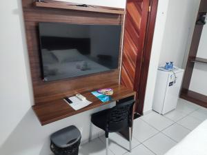 a room with a desk with a mirror and a bed at Da Silva residência à 200 metros da praia do Bessa in João Pessoa