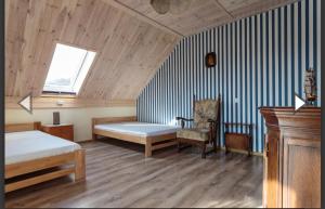a bedroom with two beds and a window and a chair at SoCloseBeach Apartament Chłopy in Chłopy