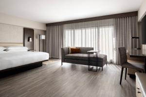 a hotel room with a bed and a chair at Marriott Riverside at the Convention Center in Riverside +39 photos