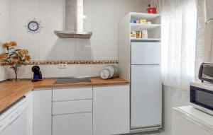 a kitchen with white cabinets and a white refrigerator at 2 Bedroom Lovely Apartment In Chipiona in Chipiona
