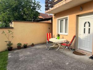 a patio with a table and chairs next to a house at Appartement Nada in Bosanski Brod