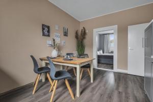 a dining room with a wooden table and chairs at HIRSCH Apartment Luchs - zentral - modern - groß in Bad Harzburg