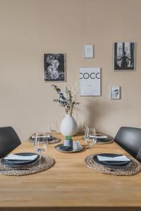 a wooden table with plates and wine glasses on it at HIRSCH Apartment Luchs - zentral - modern - groß in Bad Harzburg