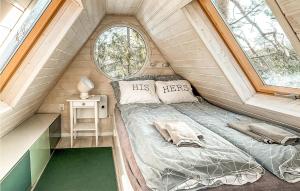 a bed in a tiny house with two windows at Nice Home In Stare Czaple With Wifi in Stare Czaple