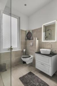 a bathroom with a toilet and a sink and a mirror at HIRSCH Apartment Luchs - zentral - modern - groß in Bad Harzburg